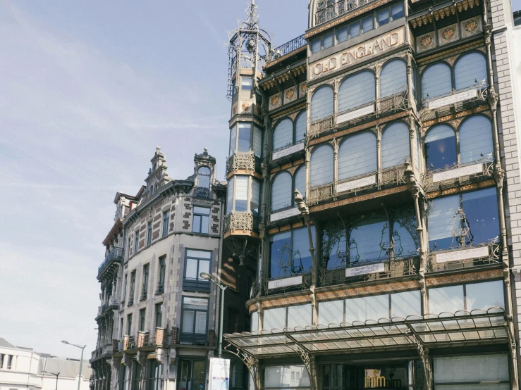 a tall building sitting on the side of a street, unsplash, art nouveau, liege, houses on stilts, shopwindows, ignacio fernandez rios ”