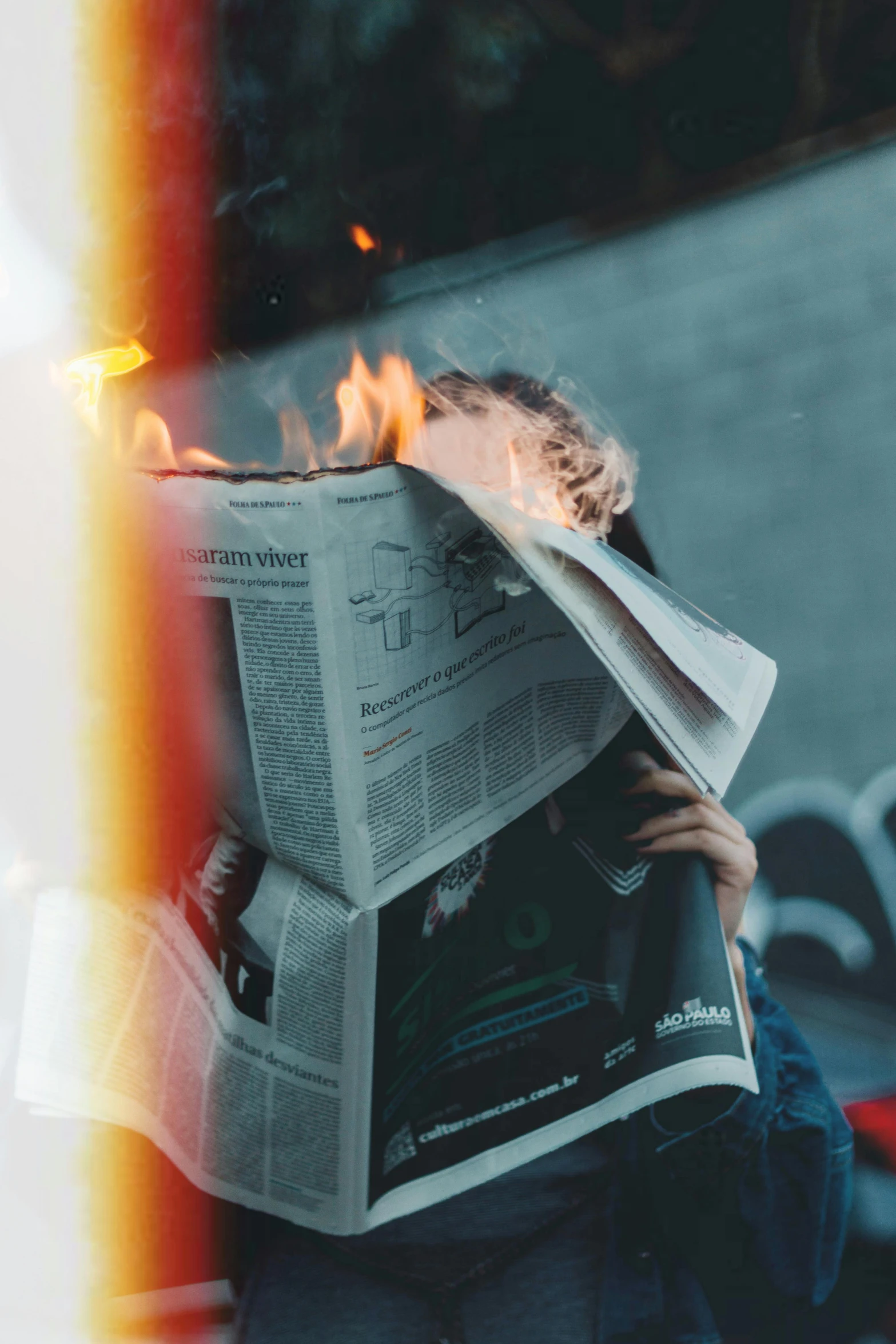 a person sitting on a bench reading a newspaper, by Niko Henrichon, unsplash contest winner, all face covered with a fire, fire above head, cardboard, brandon woelfel