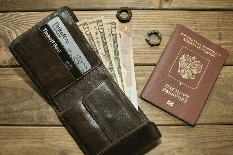 a wallet and a passport sitting on top of a wooden table, a still life, by Itshak Holtz, unsplash, service ticket close up, foster and partners, photorealistic detail, 1979