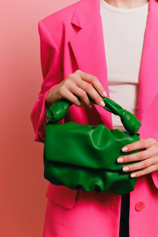 a woman in a pink suit holding a green purse, green halter top, full product shot, zoomed in, wearing leather