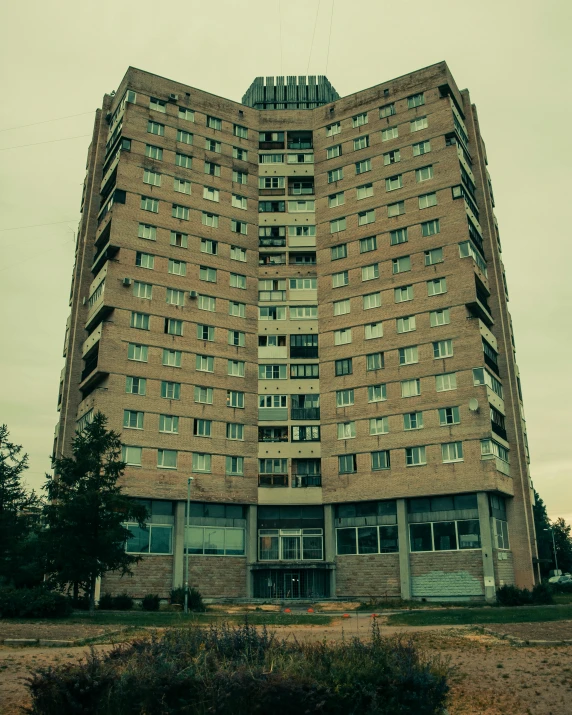 a tall building sitting in the middle of a field, an album cover, inspired by Elsa Bleda, unsplash, brutalism, nursing home, soviet apartment building, photo taken in 2 0 2 0, medical complex