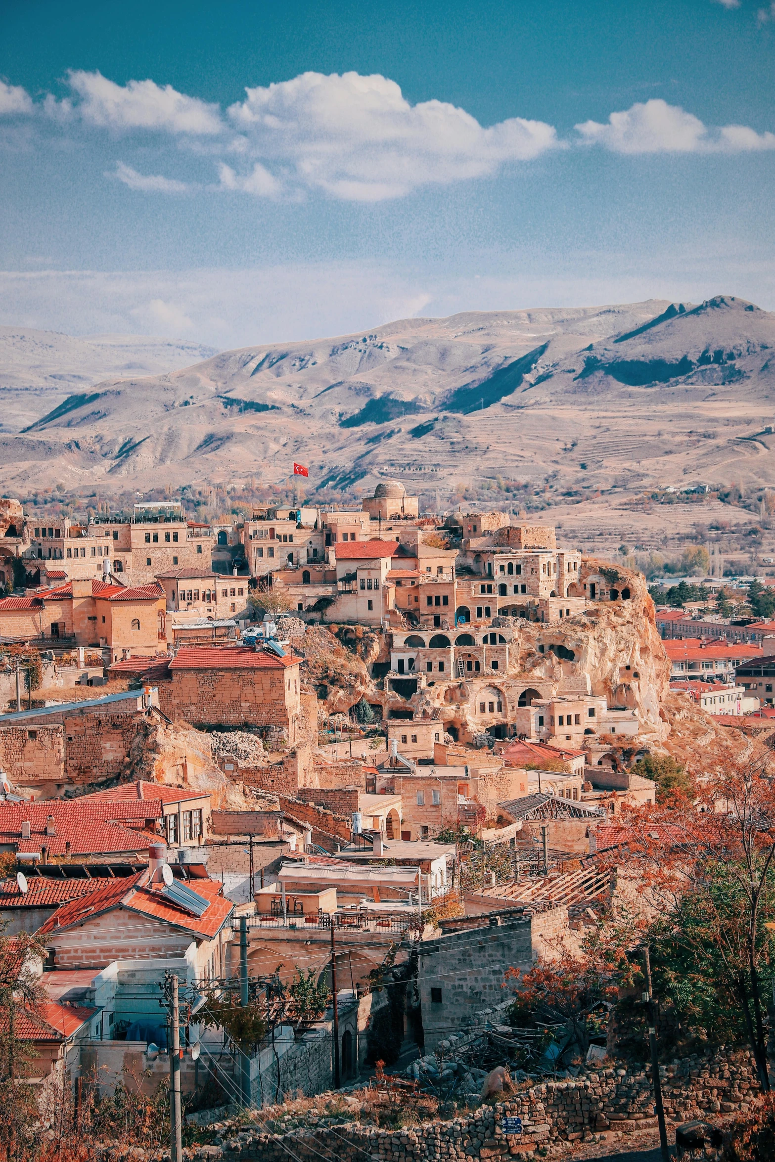 a view of a small town with mountains in the background, a colorized photo, trending on pexels, renaissance, mardin old town castle, slide show, high view, 8 x