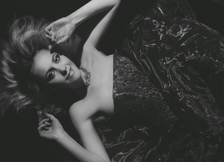a black and white photo of a woman laying down, a black and white photo, inspired by George Hurrell, pexels, renaissance, beautiful alison brie magician, wearing a sparkling dress, annasophia robb, evanna lynch