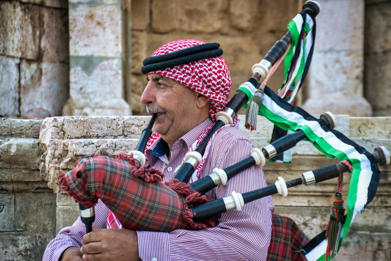 a man that is sitting down with a bagpipe, pexels contest winner, dau-al-set, jordan, avatar image, mediterranean, 2022 photograph