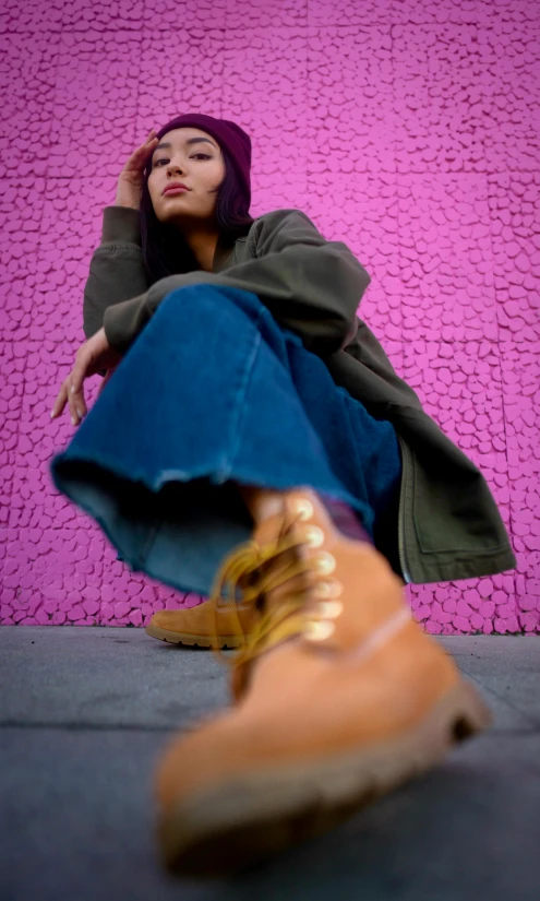 a woman sitting on the ground next to a purple wall, an album cover, by Nyuju Stumpy Brown, pexels, tight blue jeans and cool shoes, 15081959 21121991 01012000 4k, cinestill 800t eastmancolor, autum