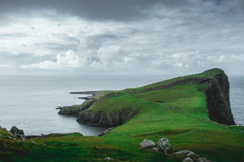 a couple of sheep standing on top of a lush green hillside, pexels contest winner, happening, stormy coast, whealan, an island, geological strata