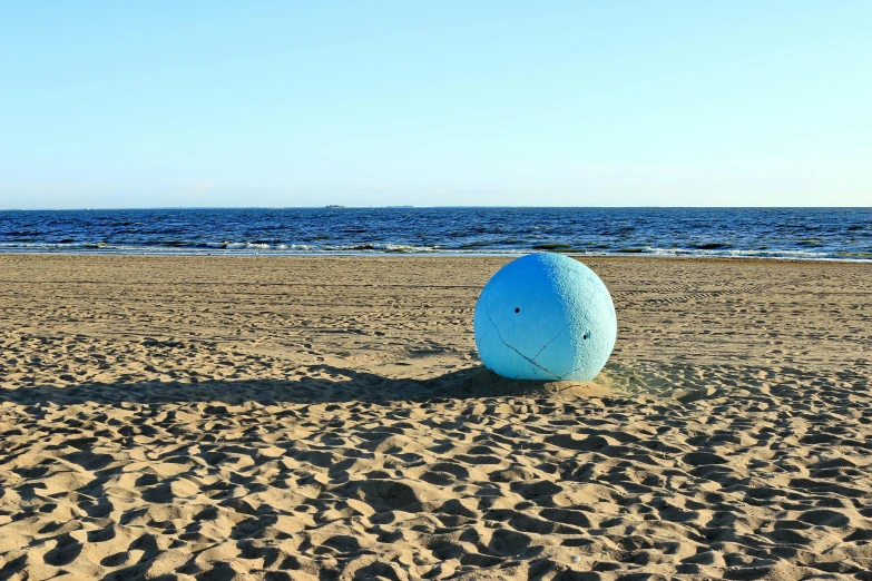 a blue ball sitting on top of a sandy beach, sitting down, eero aarnio, from the distance