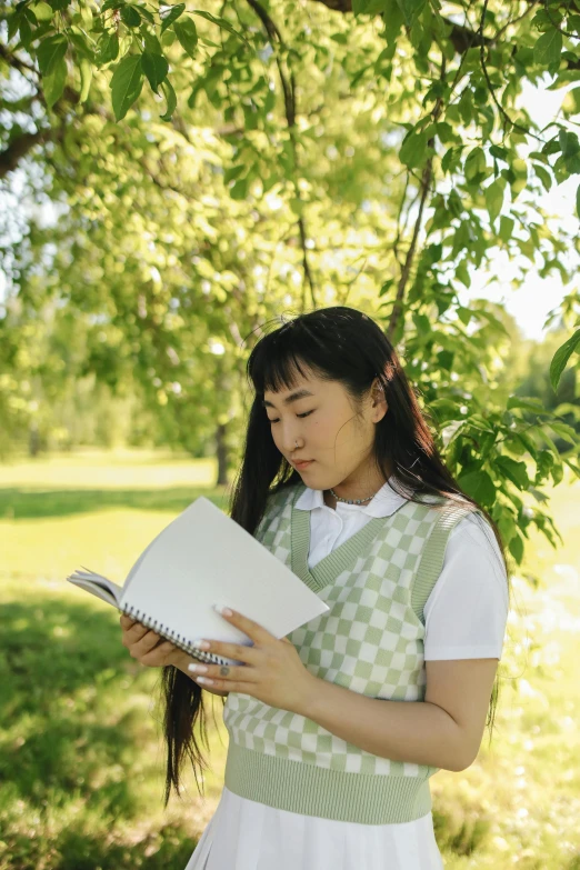 a girl reading a book under a tree, an album cover, inspired by Kim Jeong-hui, pexels contest winner, wearing a white button up shirt, holding notebook, concerned expression, profile picture