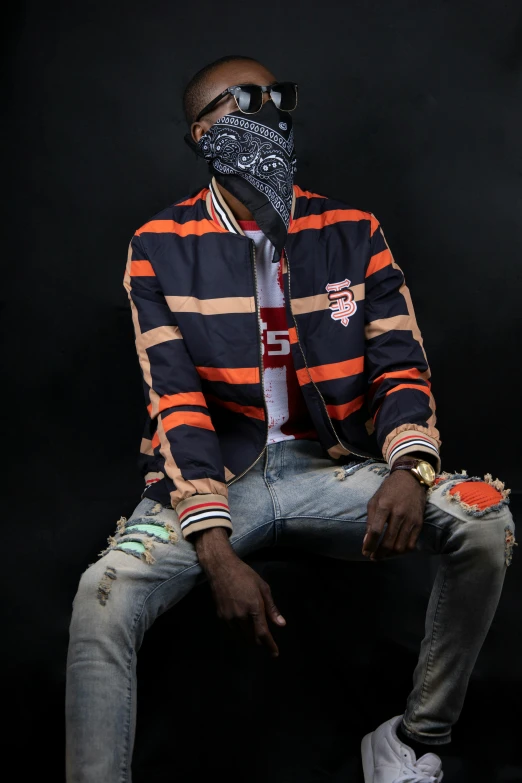 a man sitting on a chair wearing a mask, an album cover, unsplash, lyco art, orange jacket, wearing a bandana and chain, ( ( dark skin ) ), casual pose