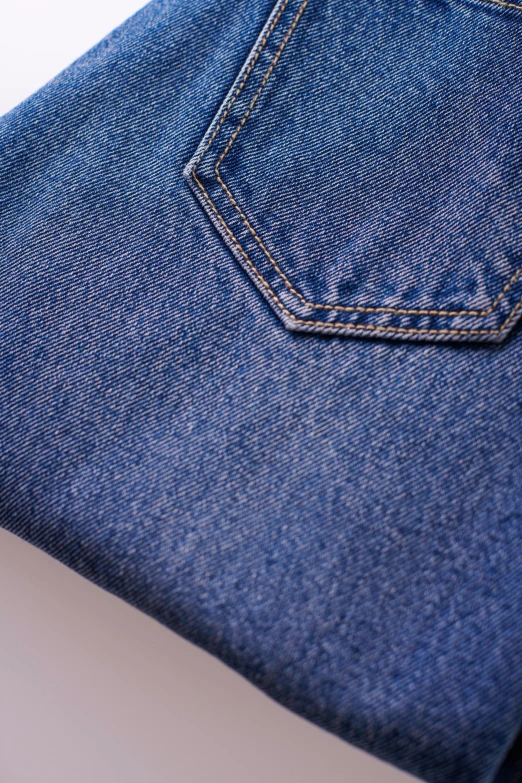 a pair of jeans sitting on top of a table, up-close, medium blue, low detail, high detail photograph