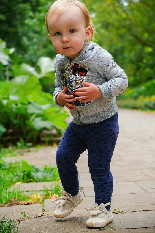 a toddler playing with a frisbee on a sidewalk, by Sven Erixson, pixabay contest winner, leggings, standing in a botanical garden, portrait full body, low detail