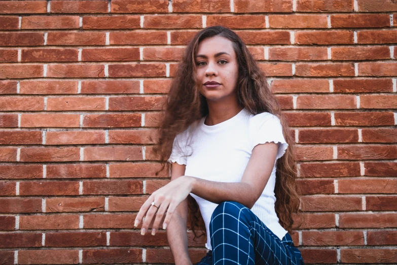 a woman sitting in front of a brick wall, pexels contest winner, antipodeans, teenage vanessa morgan, fair olive skin, 15081959 21121991 01012000 4k, portrait of white teenage girl