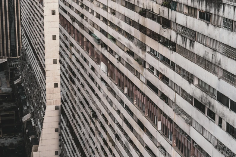 a couple of tall buildings next to each other, a photo, inspired by Andreas Gursky, pexels contest winner, brutalism, location ( favela _ wall ), square lines, low detail, an abandoned old