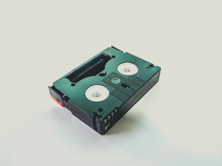 a video cassette sitting on top of a white surface, unsplash, a green, cassette, ignant, 3 d print