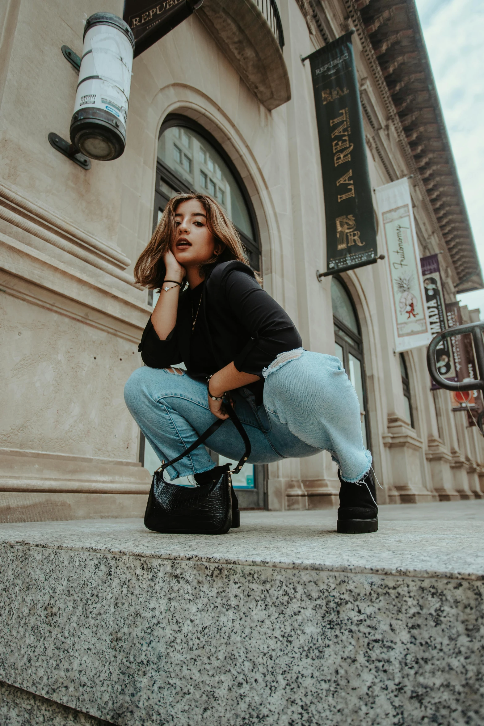 a woman sitting on the steps of a building, by Robbie Trevino, baggy jeans, cindy avelino, about to step on you, doing a sassy pose