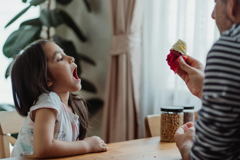 a little girl sitting at a table eating a piece of cake, by Emma Andijewska, pexels contest winner, screaming yelling, strawberry ice cream, avatar image, families playing