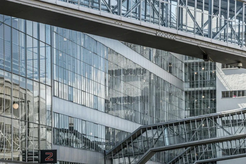 a bus driving down a street next to a tall building, inspired by Robert Zünd, pexels contest winner, brutalism, metallic bridge, glass and metal : : peugot onyx, 1 staircase, detail structure