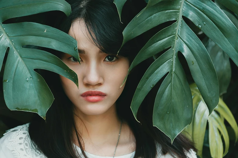 a woman standing in front of a bunch of green leaves, inspired by Ren Hang, trending on pexels, hyperrealism, young cute wan asian face, tropical, half asian, hiding