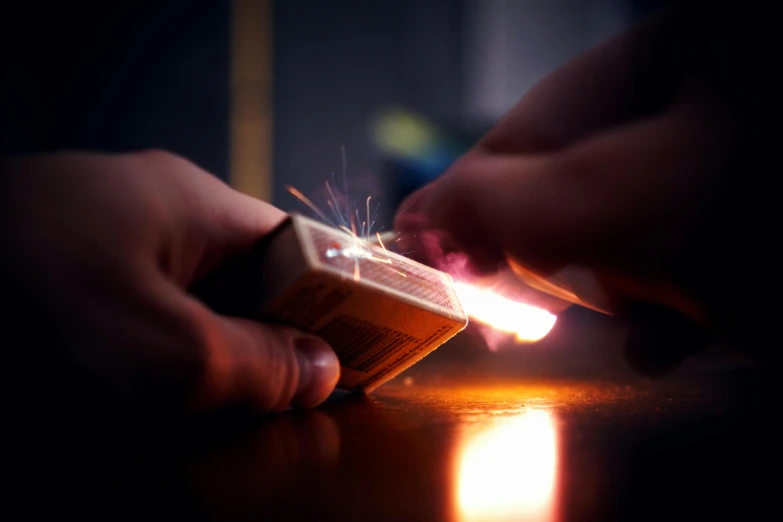 a close up of a person holding a lighter, pexels contest winner, hyperrealism, card game, explosive energy, small people with torches, hand on table