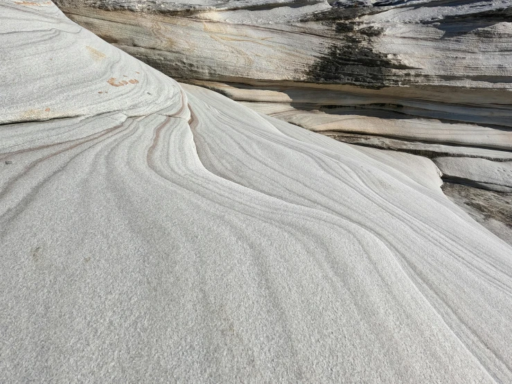 a rock formation in the middle of a desert, inspired by William Congdon, unsplash, figuration libre, rippled white landscape, sandstone, flowing shimmering fabrics, soft-sanded coastlines