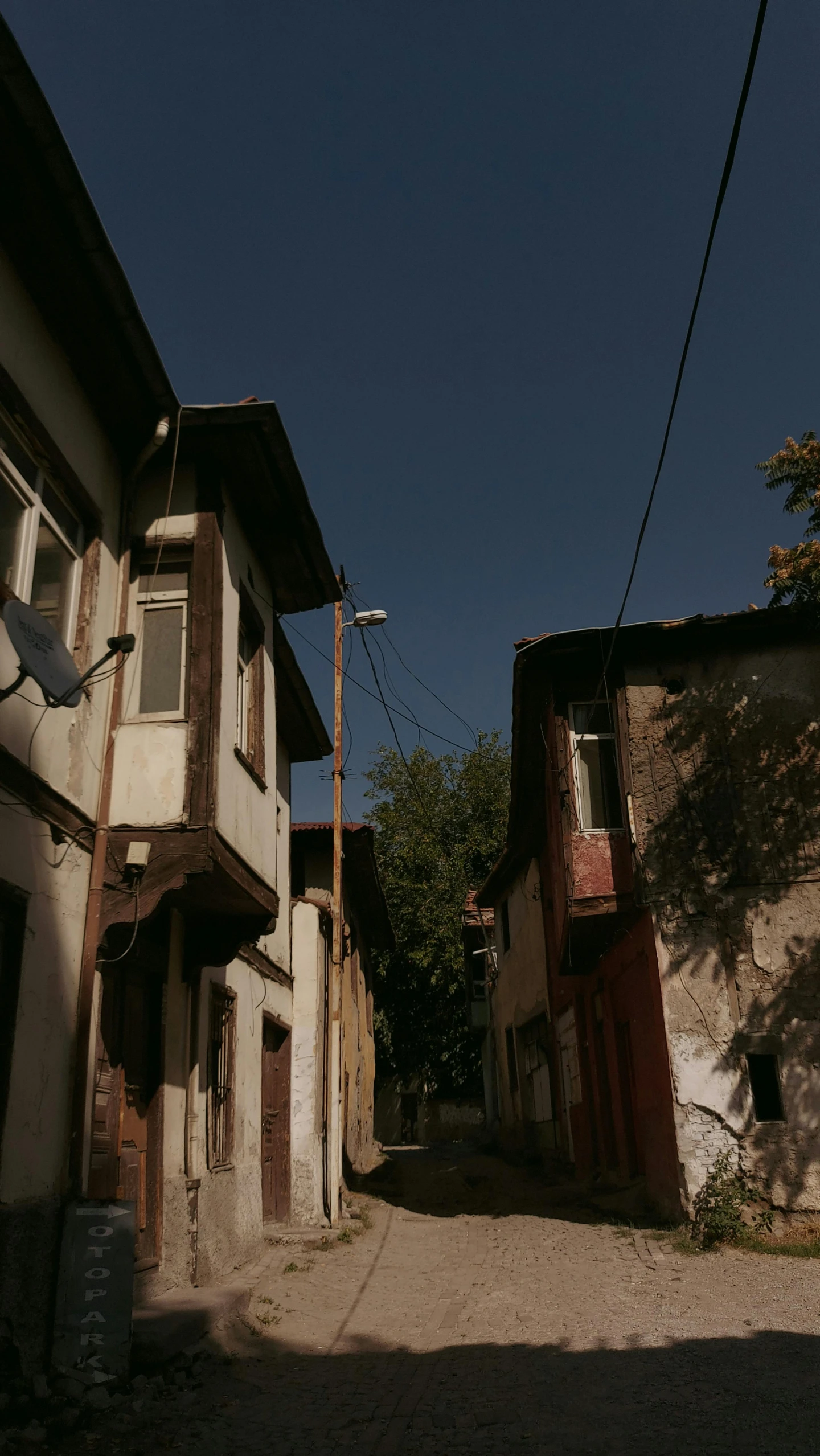 a person riding a skateboard down a street, by Attila Meszlenyi, hurufiyya, small houses, shady alleys, 8k 28mm cinematic photo, turkey