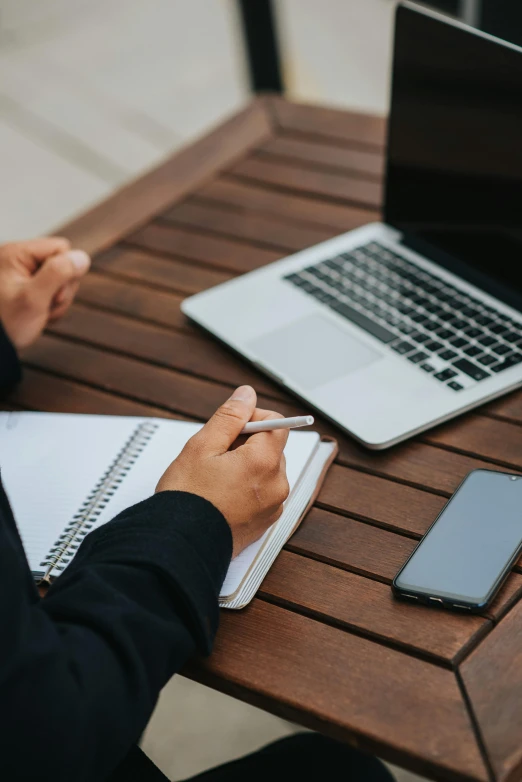 a person sitting at a table with a laptop and cell phone, lined paper, professional grade, thumbnail, notebook