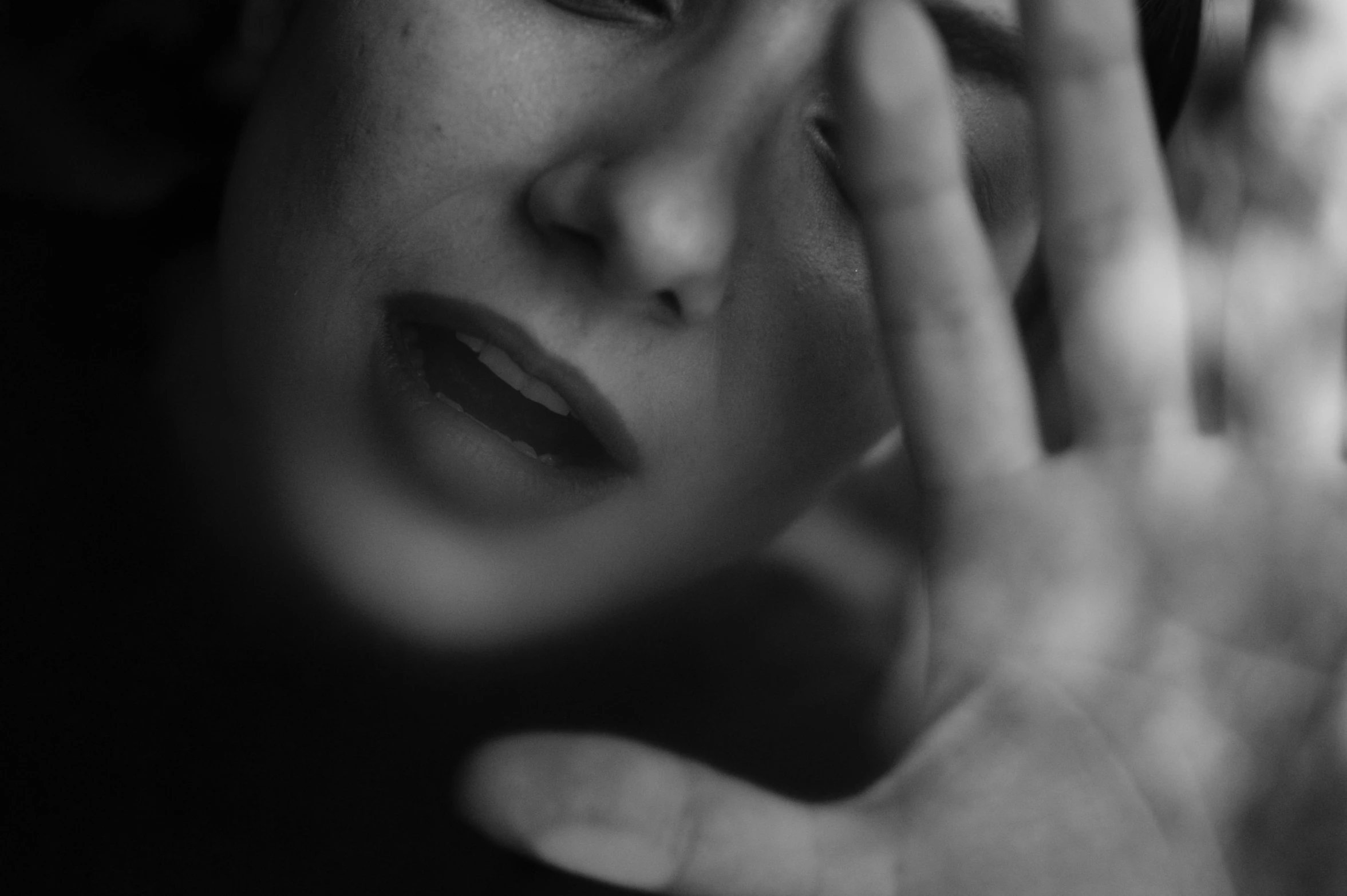 a black and white photo of a woman holding her hand to her face, pexels, surrealism, woman crying, professional closeup photo, blurry, ad image