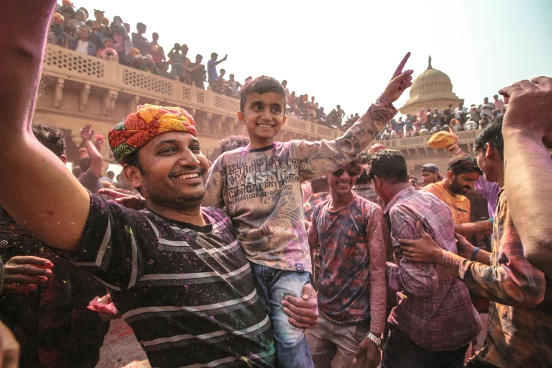 a group of men standing next to each other in front of a crowd, pexels contest winner, cheerful colours, families playing, hindu aesthetic, a still of a happy