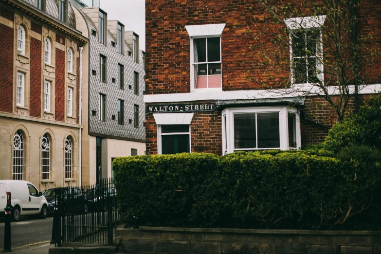 a white van parked in front of a brick building, by John Wollaston, pexels contest winner, arts and crafts movement, colonial era street, view from a distance, hull, payne's grey and venetian red