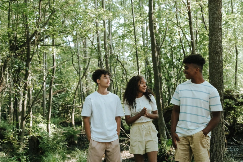 a group of people standing next to each other in the woods, by Carey Morris, pexels, renaissance, black teenage boy, dressed in a white t shirt, al fresco, willow smith zendaya