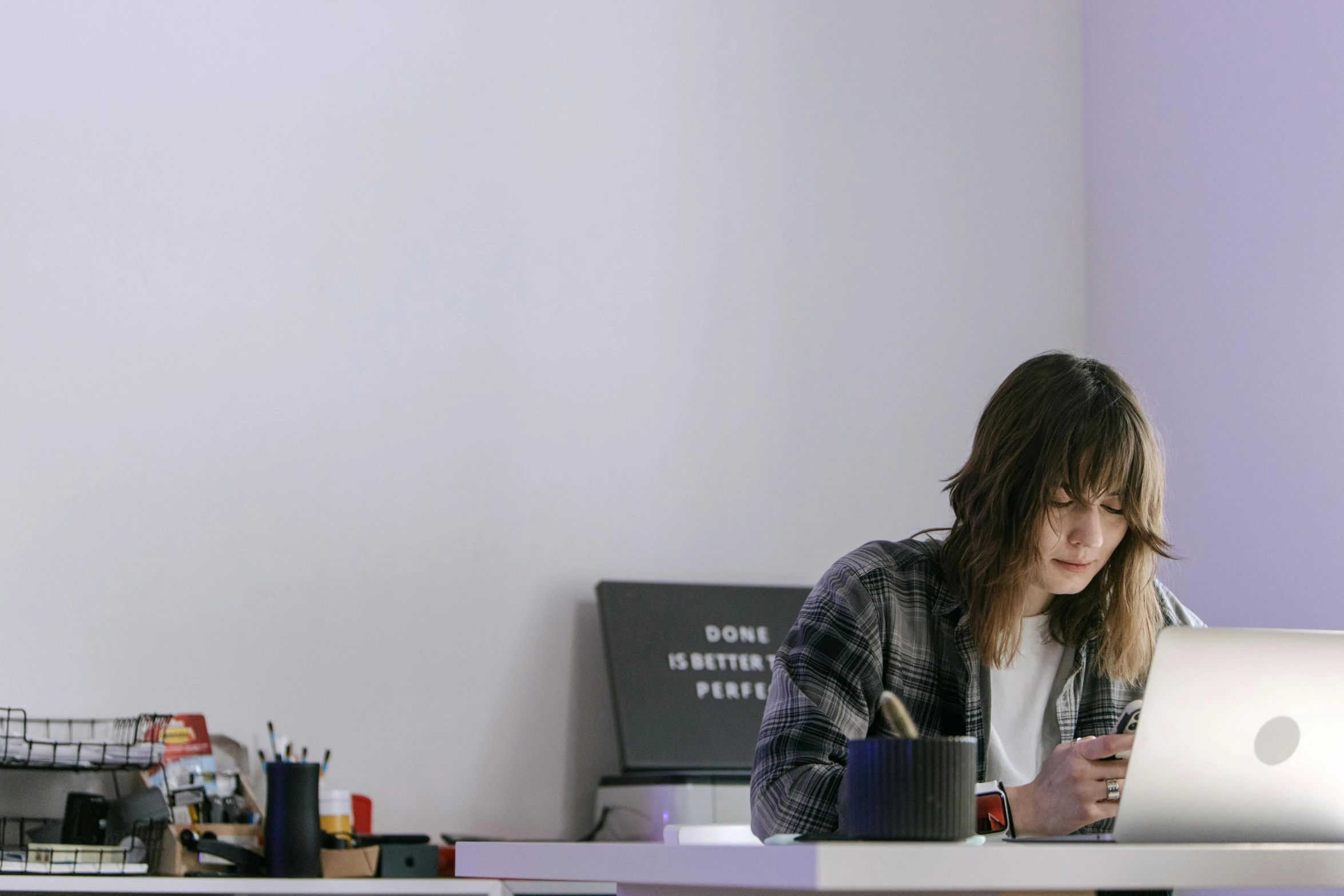 a woman sitting at a desk using a laptop computer, a photorealistic painting, trending on pexels, hyperrealism, finn wolfhard, in a open-space working space, looking at his phone, standing in class