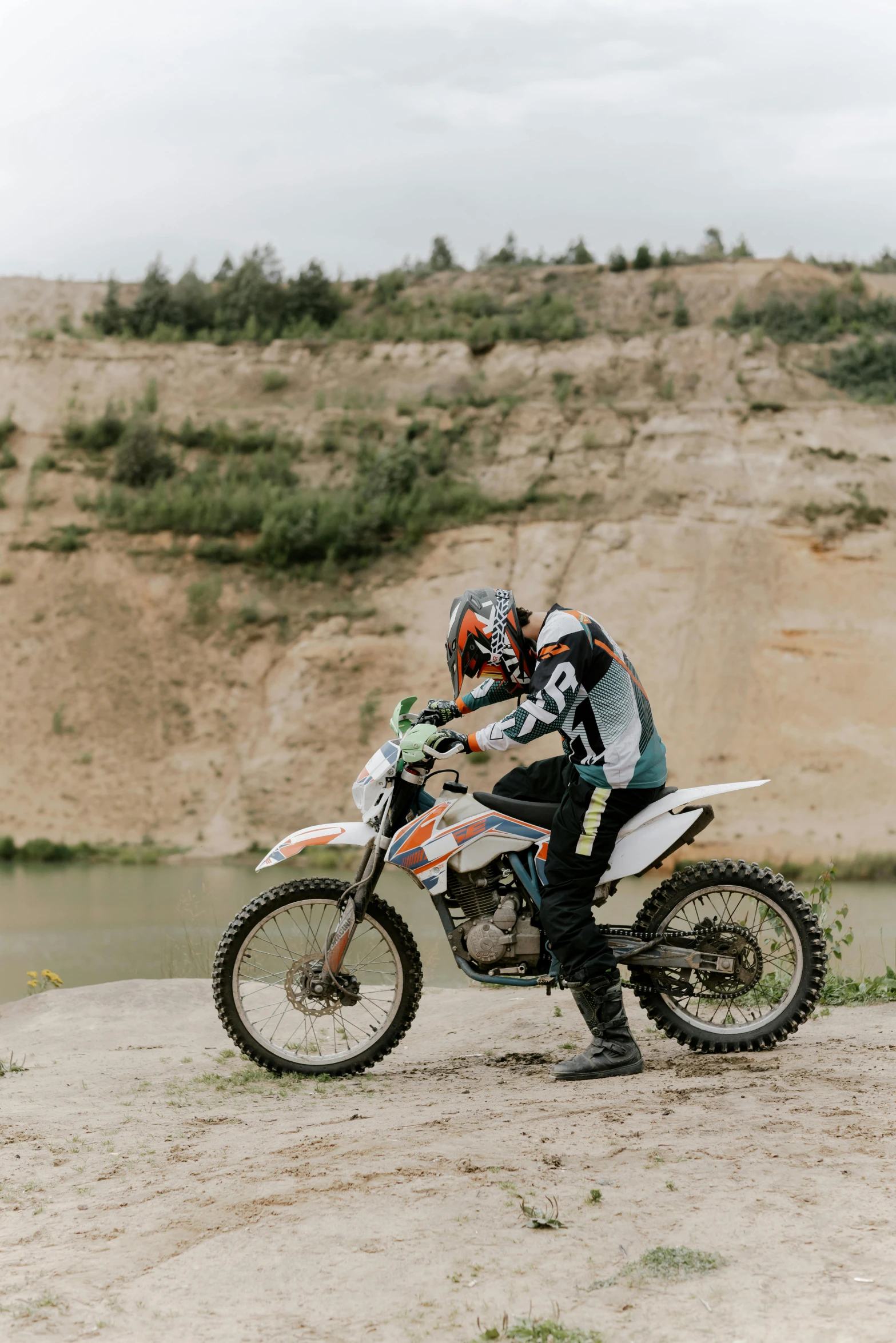 a man riding on the back of a dirt bike, pexels contest winner, figuration libre, off-white plated armor, 2 5 6 x 2 5 6 pixels, contemplating, extreme panoramic