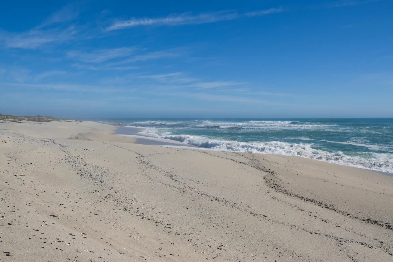 a man riding a surfboard on top of a sandy beach, the ocean, beach on the outer rim, craigville, white beaches