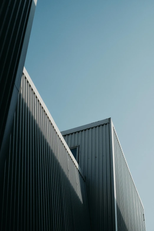 a couple of buildings that are next to each other, a picture, pexels contest winner, modernism, galvalume metal roofing, square lines, blue, graphite