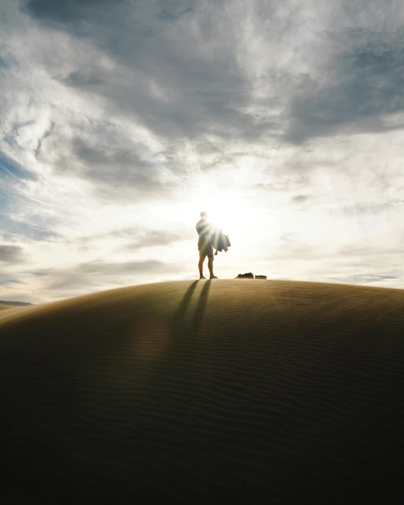 a person standing on top of a sand dune