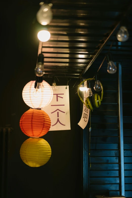 a bunch of paper lanterns hanging from a ceiling, a silk screen, by Sengai, unsplash, mingei, glowing street signs, studio photo, yan, sconces