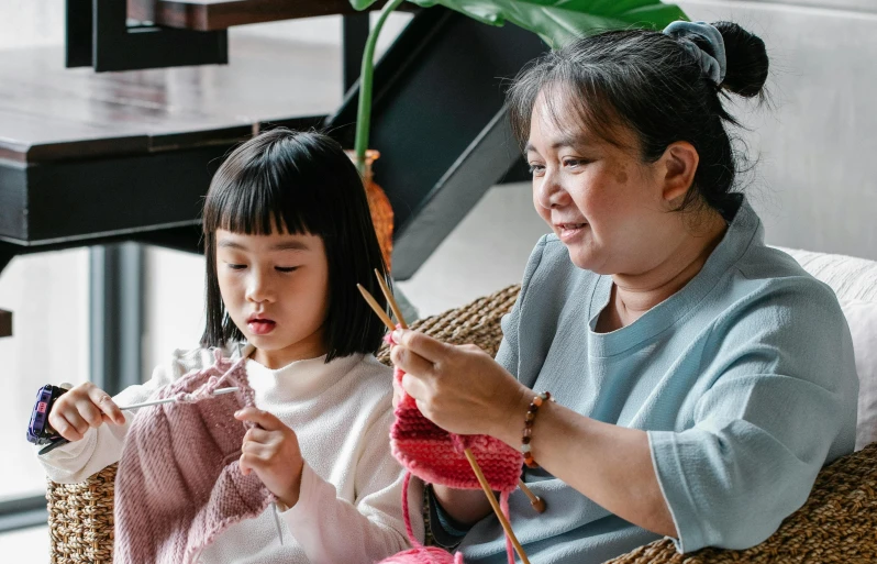 a woman and a little girl sitting on a couch, inspired by Ruth Jên, pexels contest winner, arts and crafts movement, yarn, korean woman, intarsia, youtube thumbnail