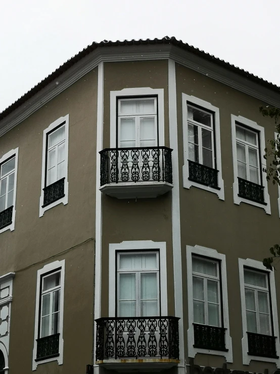 a tall building with many windows and balconies, an album cover, by Yasar Vurdem, pexels contest winner, colonial style, grey, bay window, 2. sigara aşırmak