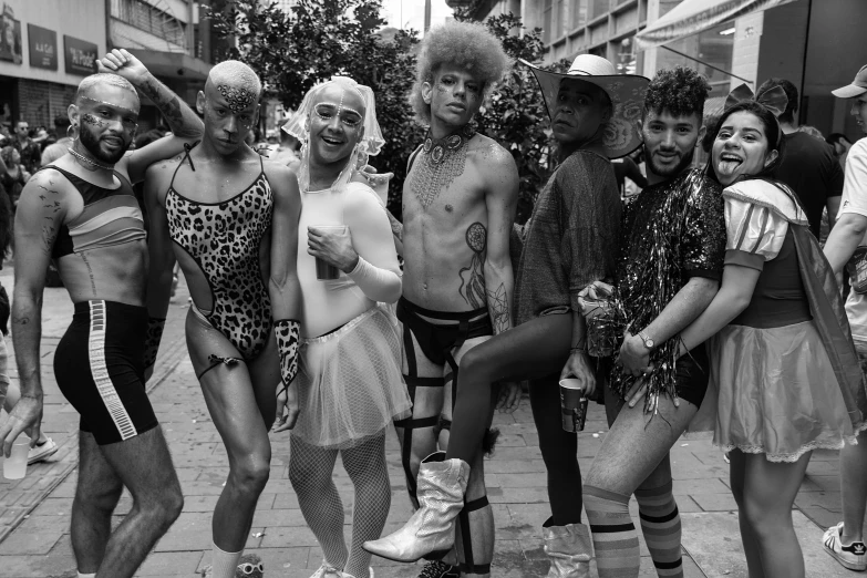 a group of people standing next to each other on a street, a black and white photo, by Judith Gutierrez, renaissance, drag, in sao paulo, wild rave outfit, gray men