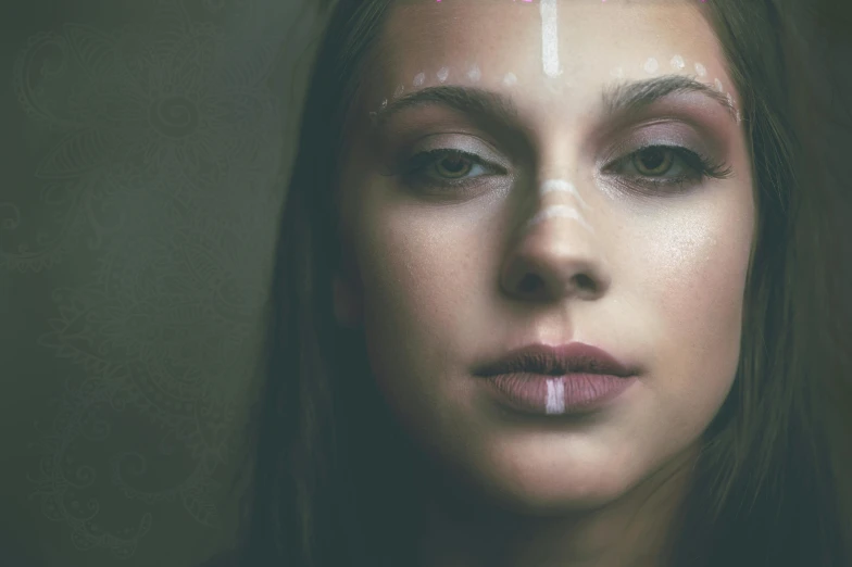 a woman with a cross painted on her face, inspired by Elsa Bleda, pexels contest winner, aestheticism, portrait of a norse moon goddess, clean symmetrical faces, beautiful young female shaman, color photograph portrait 4k