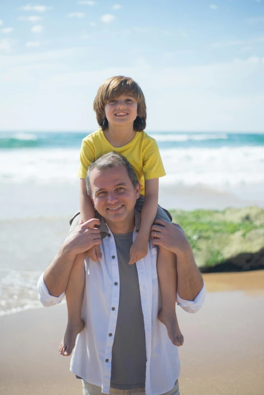 a man carrying a little boy on his shoulders on the beach, manly, highly relaxed, caring fatherly wide forehead, slide show