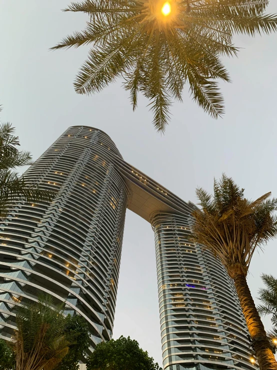 a couple of tall buildings sitting next to each other, an album cover, inspired by Zaha Hadid, pexels contest winner, renaissance, palms and miami buildings, exterior view, islamic, lush surroundings