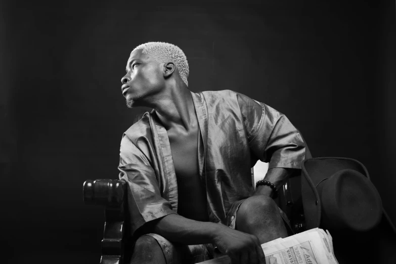 a black and white photo of a man sitting on a chair, an album cover, inspired by David Bailly, pexels, emmanuel shiru, silver haired, portrait of muscular, 15081959 21121991 01012000 4k
