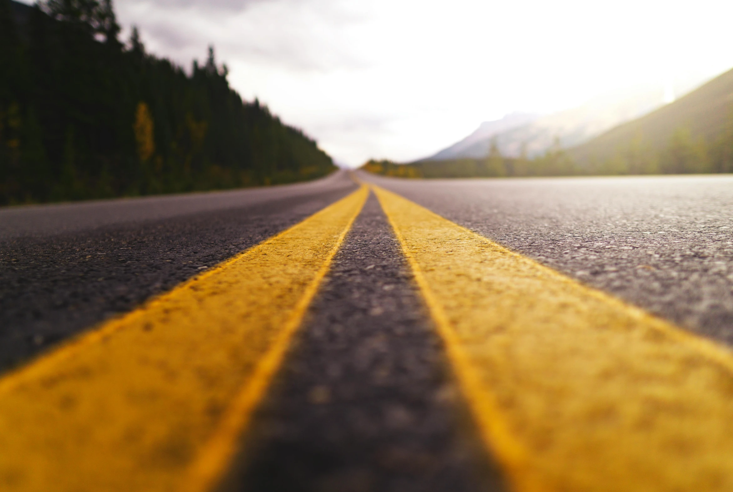 a yellow line in the middle of a road, by Carey Morris, unsplash, hills in the background, an extreme closeup shot, 🚿🗝📝, thumbnail