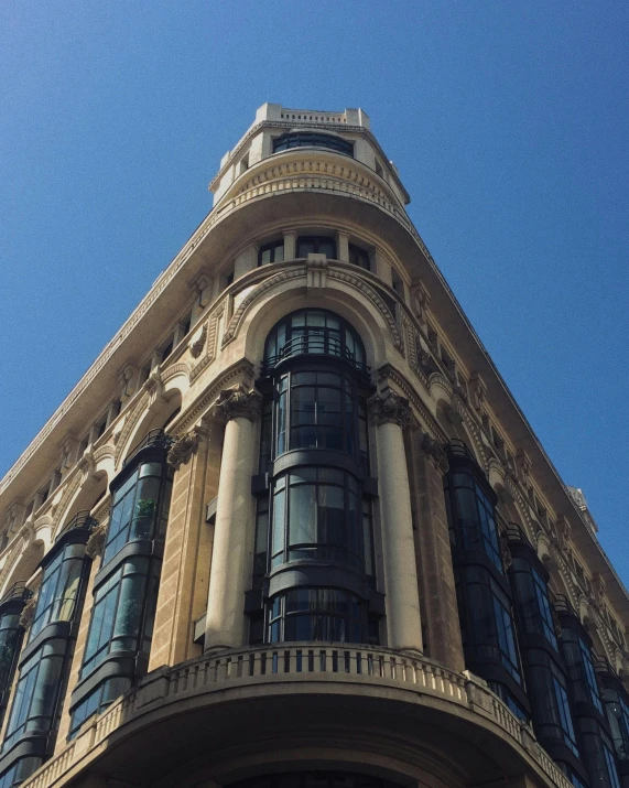 a tall building with a clock on the top of it, inspired by Tomàs Barceló, unsplash, art nouveau, shopwindows, madrid, thumbnail, looking left