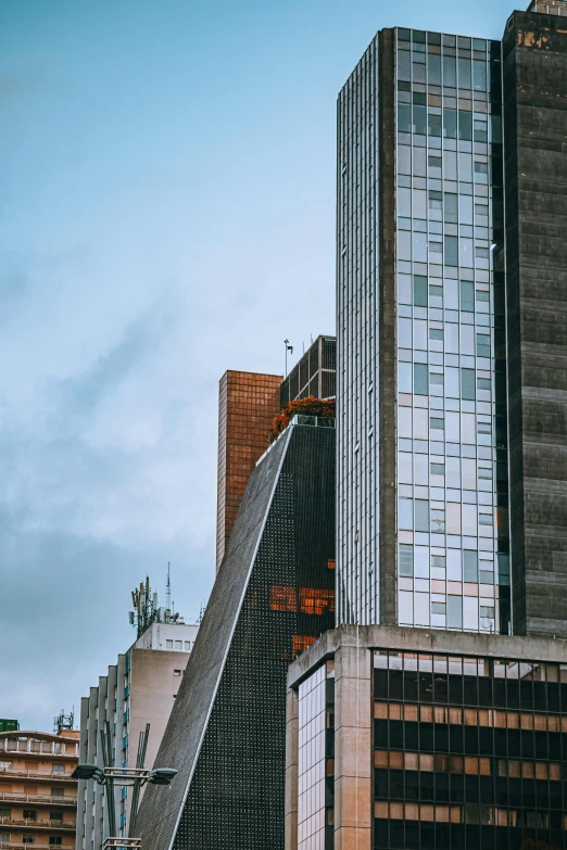 a very tall building sitting in the middle of a city, unsplash, brutalism, side profile shot, neo - andean architecture, view from side, telephoto shot