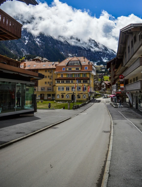 a street with buildings and mountains in the background, lauterbrunnen valley, paved roads, square, today\'s featured photograph 4k