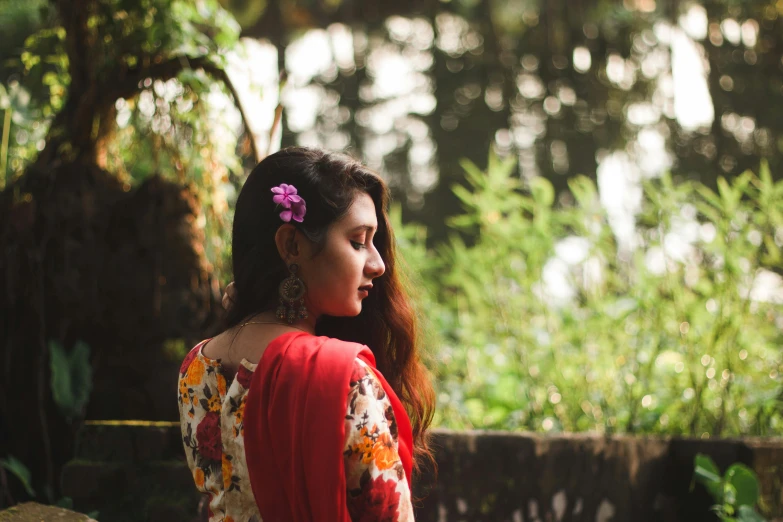 a woman with a flower in her hair, inspired by Sunil Das, pexels contest winner, hurufiyya, wearing a kurta, from the distance, crimson themed, wearing a hawaiian dress