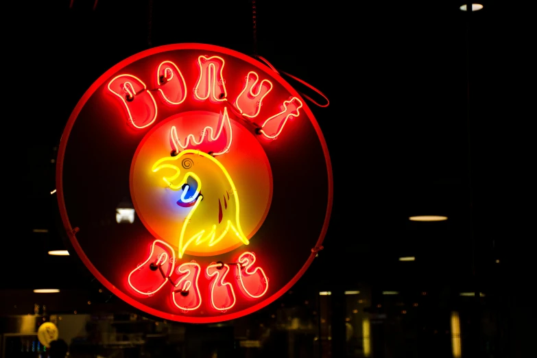 a neon sign hanging from the side of a building, by Doug Ohlson, pexels, rooster, donut, dale odell, soft rim light