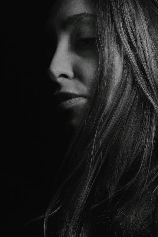 a black and white photo of a woman with long hair, pexels contest winner, in style of britt marling, detailled face, lit from the side, downward gaze